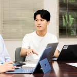 ＺＢＯＳＡＩ代表の谷口隆英さん（右から２人目）。活動を共にするメンバーとの議論にも熱がこもる＝西宮市内