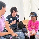 診療中の子どもの緊張を和らげるため声をかける成俊浩さん（左から２人目）＝ベネズエラのラグアイラ州、国際協力機構（ＪＩＣＡ）提供