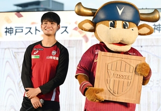 神戸の木材で作ったヴィッセル神戸のチームロゴのレリーフと、佐々木大樹選手＝１日午後、神戸市中央区波止場町（撮影・斎藤雅志）