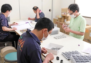 電子部品の組み立て作業を行う利用者ら＝姫路市内の作業所