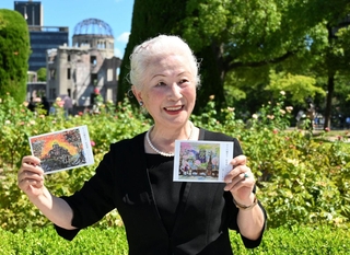 原爆ドームをモチーフにした自身の絵のハガキを手に平和への思いを語る内藤幸子さん＝６日午前、広島市中区