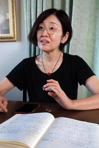 父が残した日記を開き、思いを語る中西利香さん＝いずれも明石市大蔵八幡町（撮影・吉田敦史）