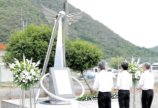 復興モニュメントに花をたむける江見秀樹町長（中央）ら＝兵庫県佐用町久崎、復興ひろば