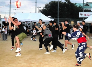 盆踊りに加わって場を盛り上げる実行委員の高島淳史さん（左）＝姫路市東今宿５