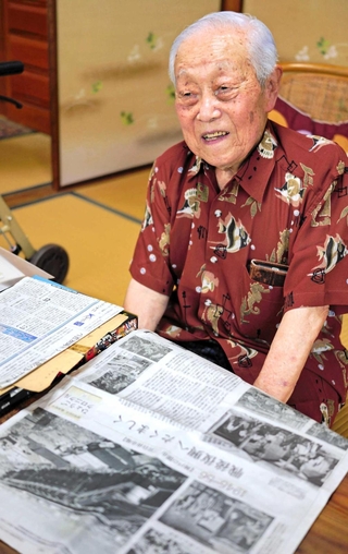神戸・三宮や元町の闇市を特集した神戸新聞の紙面を前に、当時の思い出を語る森茂さん＝神戸市灘区水道筋３