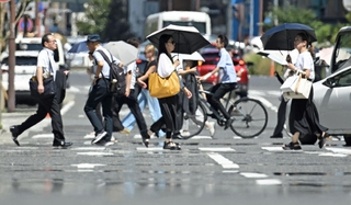 暑さの影響で市街地の道路に現れた「逃げ水」＝２４日午後、神戸市中央区