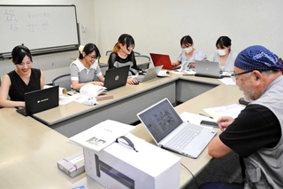文化財情報のデジタル化に励む武庫川女子大学の学生と「さんだアートガーデン」の海野芳樹副理事長（右）＝三田市駅前町