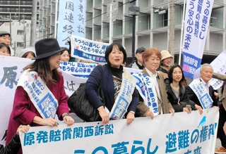 大阪地裁前で支援者らと行進する森松明希子さん（左から２人目）と菅野昭雄さん（右端）＝２０２５年１２月、大阪市北区