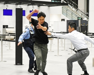 逃走を図る容疑者役（中央）を取り押さえようとする警察官ら＝神戸市中央区、神戸空港