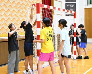 体験会で保護者スタッフらと一緒にゴールの設営をする生徒＝神戸市立横尾中学校