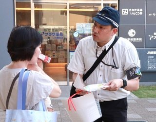 情報提供を呼びかけるビラを配る捜査員ら＝３１日午後、神戸市灘区灘北通５