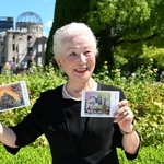 原爆ドームをモチーフにした自身の絵のハガキを手に平和への思いを語る内藤幸子さん＝６日午前、広島市中区