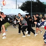 盆踊りに加わって場を盛り上げる実行委員の高島淳史さん（左）＝姫路市東今宿５