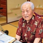 神戸・三宮や元町の闇市を特集した神戸新聞の紙面を前に、当時の思い出を語る森茂さん＝神戸市灘区水道筋３