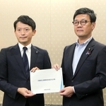 総務省の梶原大介政務官（右）に「公債費負担適正化計画」を手渡す兵庫県の斎藤元彦知事＝東京都千代田区霞が関