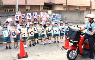 郵便局員に生活道路の法定速度引き下げを呼びかける神戸ゆたか園の園児ら＝１日午前、神戸市中央区栄町通６、神戸中央郵便局
