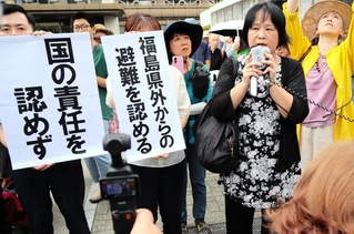 判決を受け、垂れ幕の前で胸の内を語る原告団の森松明希子代表（右から２人目）＝２日午後、大阪市北区、大阪地裁