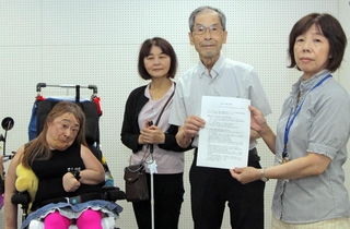 強制不妊手術の被害救済を目指し、兵庫県職員（右）に提案書を手渡す当事者と弁護士、支援者＝いずれも神戸市中央区東町、中央区文化センター