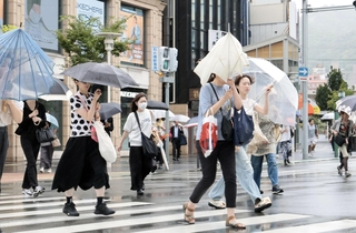 強い雨風の中を歩く人たち＝９日午前１０時１３分、神戸市中央区（撮影・鈴木雅之）