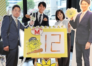 阪神タイガースのセ・リーグ連覇を信じてマジックナンバー看板を用意するサンテレビの河合皓稀アナ（中央左）と編成部の木村綾さん（同右）＝神戸市中央区東川崎町１