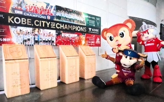 優勝を記念して作られたレリーフと写真に納まる各チームのマスコット＝神戸市役所