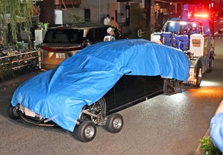 現場のガレージの中にある車を運び出すレッカー車＝30日午後８時４分、神戸市兵庫区荒田町