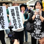 判決を受け、垂れ幕の前で胸の内を語る原告団の森松明希子代表（右から２人目）＝２日午後、大阪市北区、大阪地裁
