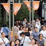 強風にあおられながら歩く人たち＝６日午後、神戸市中央区東川崎町１