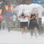 たたきつけるような激しい雨が降る中を歩く人たち＝８日午前、神戸市中央区東川崎町１（撮影・鈴木雅之）
