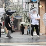 強い雨風の中を歩く人たち＝９日午前９時５９分、神戸市中央区、ＪＲ元町駅前（撮影・鈴木雅之）