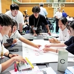 被災地との継続的な関わりをテーマに意見を出し合い、付箋を貼っていく参加者たち＝神戸市中央区脇浜海岸通１、ＪＩＣＡ関西