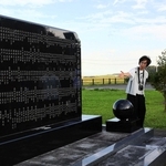 慰霊碑の前で、高校生らに東日本大震災時の状況を伝える大塚淳子さん（中央）＝福島県浪江町