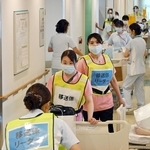 慎重に患者を移送する病院の関係者ら＝２２日午前、西宮市武庫川町、兵庫医科大病院（撮影・大田将之）