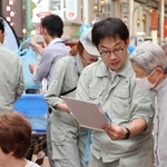 神戸市の水道ＰＲイベントで悪質業者への注意を呼びかける市水道局職員＝６月４日、同市中央区の元町３丁目商店街