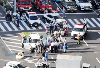 神戸国際会館前の交差点で事故処理にあたる警察官ら＝１日午後３時４６分、神戸市中央区御幸通８、フラワーロード