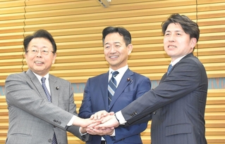 会見で写真撮影に応じる公明党の（左から）西田実仁幹事長、岡本三成代表、中野洋昌政調会長＝３日午後、東京都新宿区