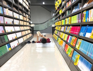 本棚の間で寝ながら読書する参加者＝２０１７年１１月、丸善名古屋本店（丸善ジュンク堂提供）