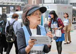 過労死等防止対策推進シンポジウムへの参加を呼び掛ける西垣迪世さんら＝１４日午後、神戸市中央区