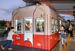 飾り付けられた赤胴車の車内外で遊び回る子どもたち＝西宮市高須町２