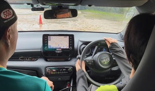 目隠しをした運転手（右）が助手席のコ・ドライバーの指示を聞いて運転する。バックミラーにアイマスクを着けた顔が映る＝神戸市西区岩岡町古郷