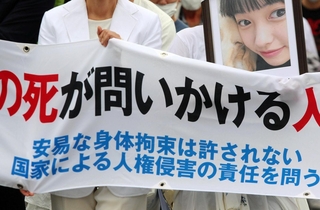 少女の写真とともに神戸地裁に入る母親（左）＝２１日午前、神戸市中央区橘通２