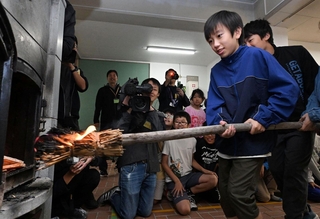 自らおこした火をストーブに移す児童たち＝２３日午前、神戸市灘区六甲山町、六甲山小学校（撮影・風斗雅博）