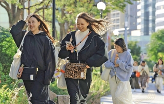 強い風に髪をあおられながら歩く女性ら＝２８日午後、神戸市中央区波止場町（撮影・吉田敦史）
