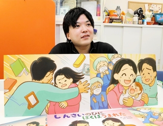 阪神・淡路大震災の発生当日に生まれた中村翼さん。自身の生まれた状況が紙芝居になった＝神戸市中央区港島１