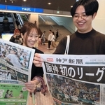 阪神タイガース初のリーグ連覇を伝える神戸新聞の号外を受け取る人たち＝４日午前、神戸市中央区東川崎町１（撮影・鈴木雅之）