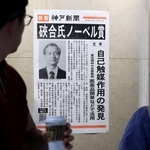 ノーベル化学賞受賞を伝える号外を見る人たち＝７日夜、デュオこうべ（撮影・丸山桃奈）