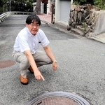 御影町章のマンホールのふたについて解説する道谷卓さん＝神戸市東灘区御影山手５