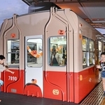 飾り付けられた赤胴車の車内外で遊び回る子どもたち＝西宮市高須町２