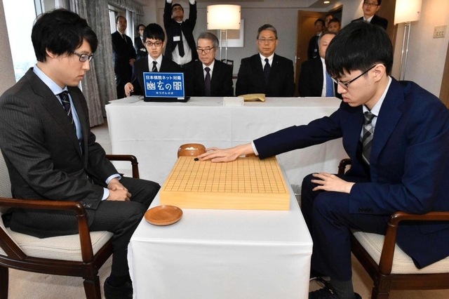 天元戦第５局で初手を打つ許家元八段（右）。左は井山裕太天元＝１８日午前、徳島市、徳島グランヴィリオホテル