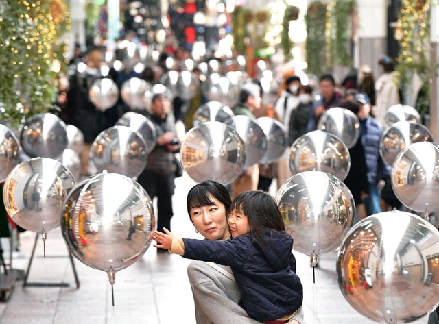 宙に浮かぶ鏡面風船を眺めながらアーケードを行き交う人たち＝２０日午後、神戸市中央区三宮町２、三宮本通商店街（撮影・秋山亮太）